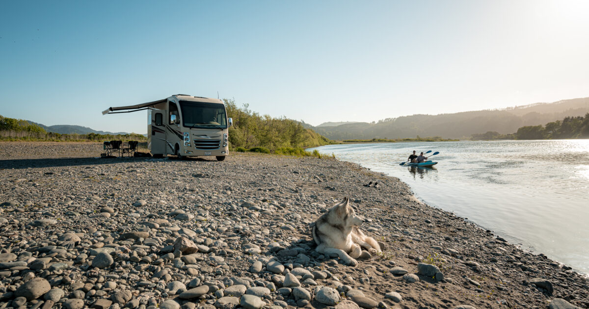 an RV set up next to a stream