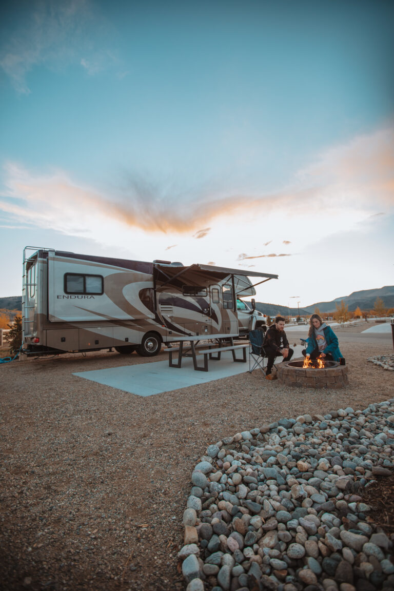 An RV parked in front of a campfire