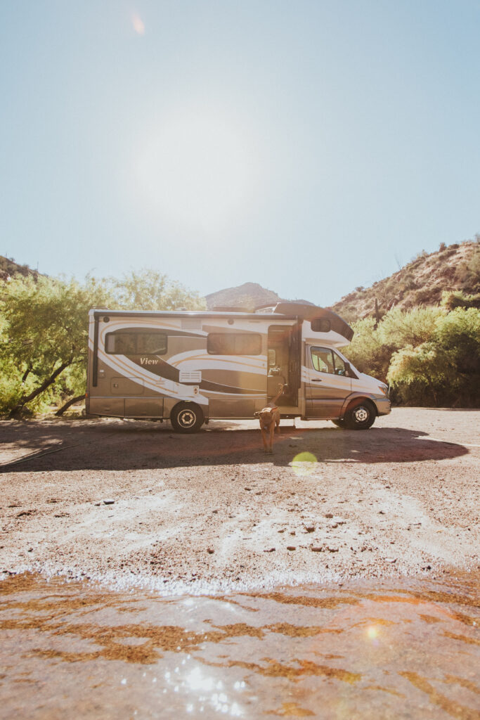 A camper set up next to a stream