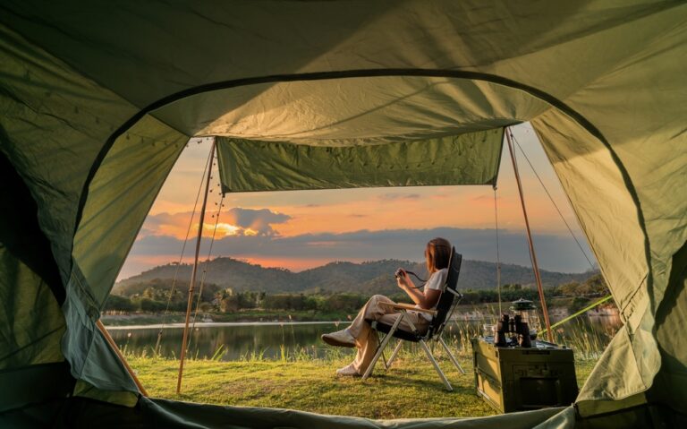 A person sitting in a chair next to a tent