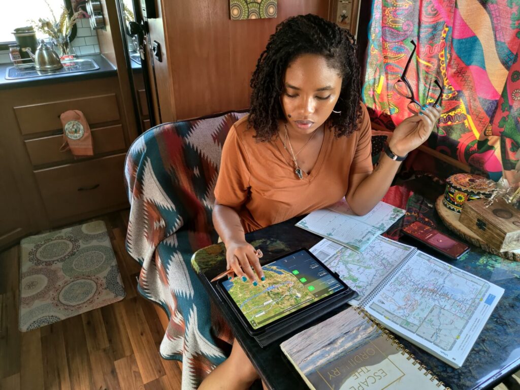 A woman planning a trip with an iPad and maps