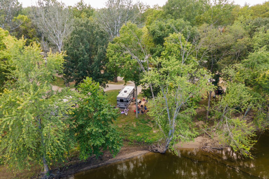 An RV parked in a tree covered campsite