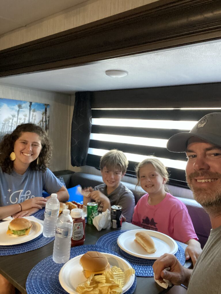 A family sitting around their RV dining table