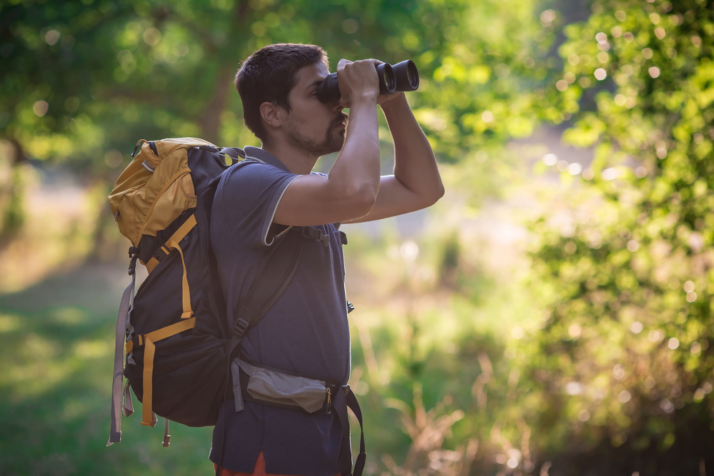 a man with a backpack and binoculars