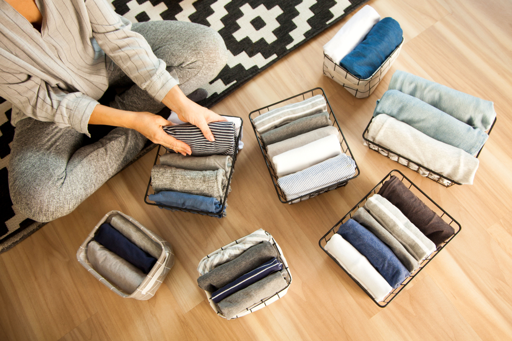 A woman folding clothes into a basket