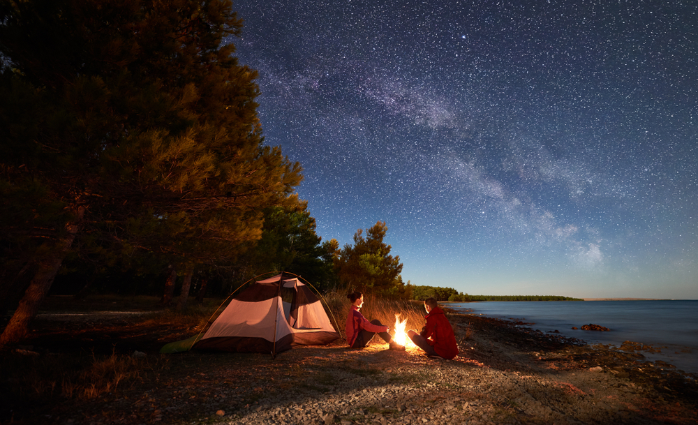 people tent camping next to a lake