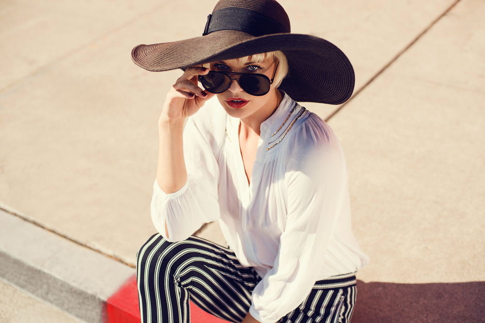 A model in a floppy hat and sunglasses