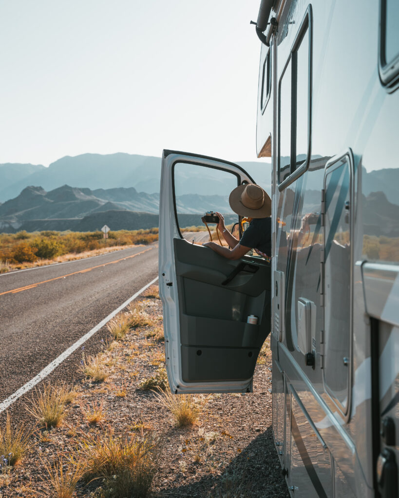 A woman leaning out the drivers side of a camper