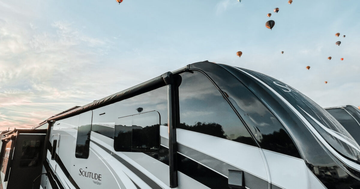 An RV trailer with hot air balloons behind