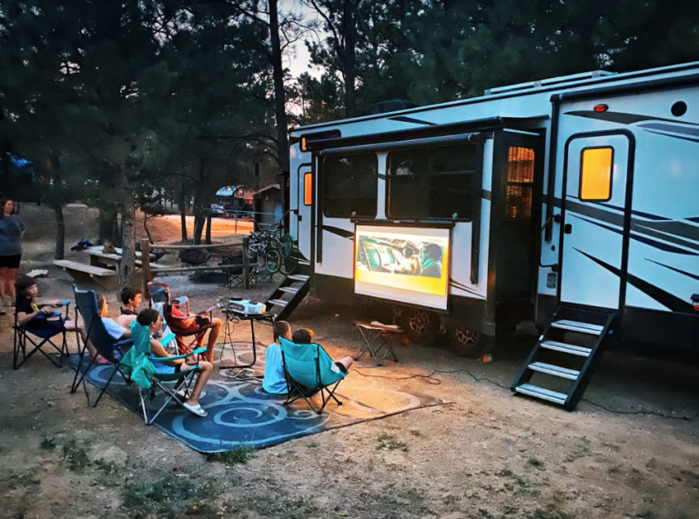 kids relaxing for movie night outside their RV