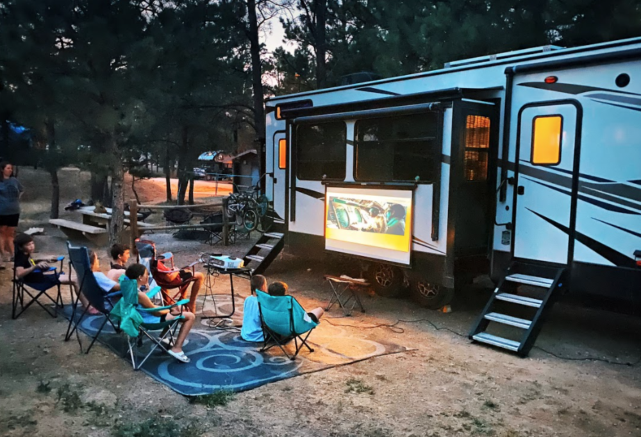 kids relaxing for movie night outside their RV