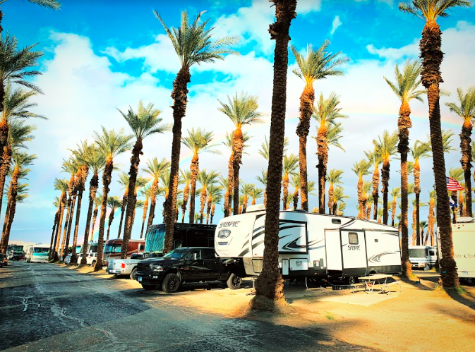 a large trailer at a campground with palm trees