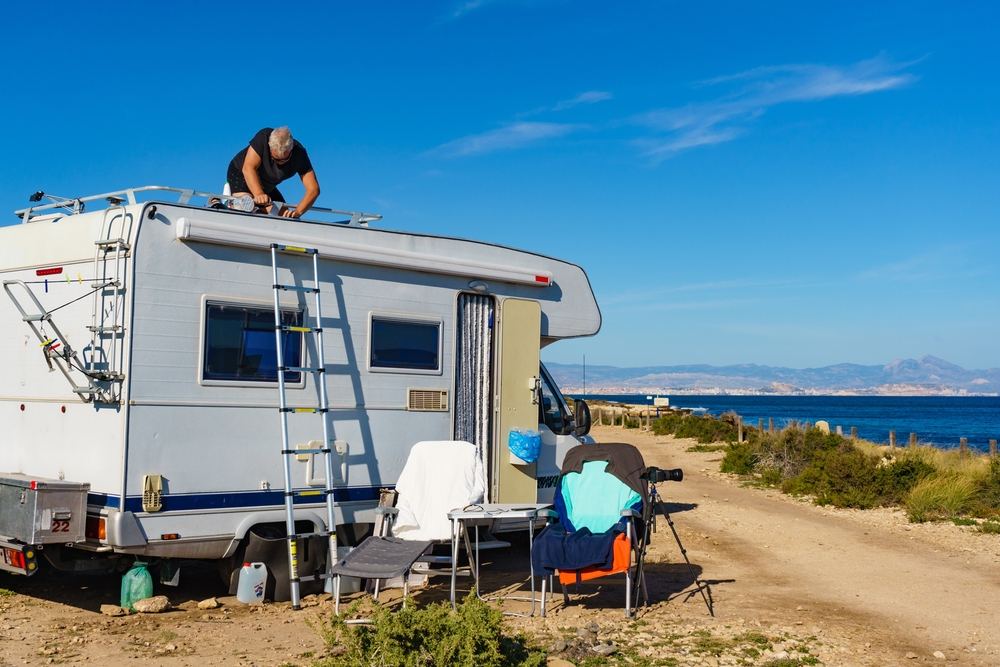 a man working on roof of RV