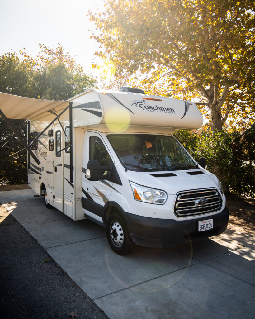 a Class C camper set up with an awning