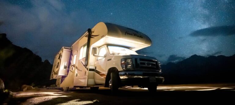 A class c motorhome lit up at night for camping