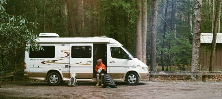 A man in a Class B RV, getting his backpack ready for the day