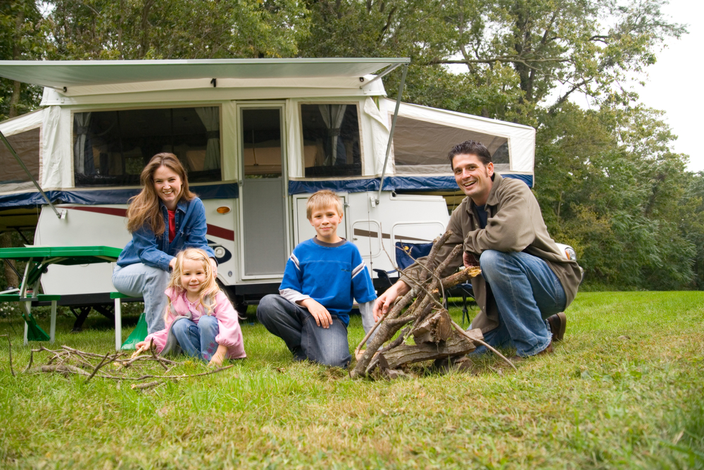 a family relaxing in front of their pop up camper