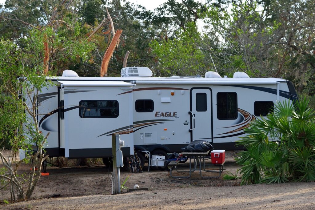 a fifth wheel trailer at a campground with palm trees