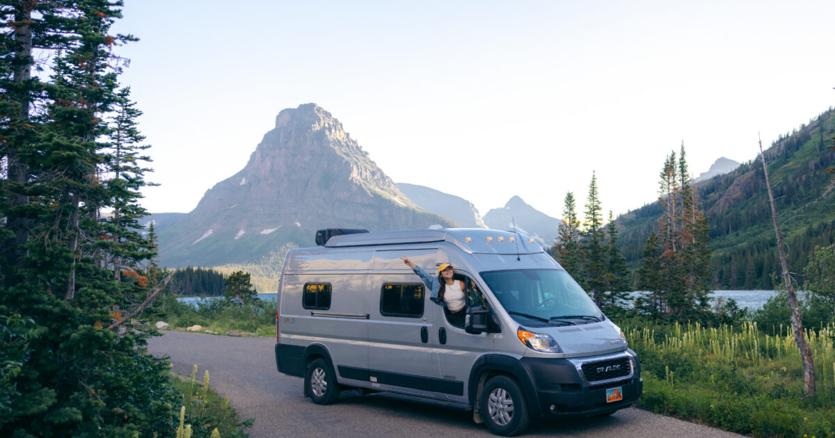 a woman leaning out the window of a campervan