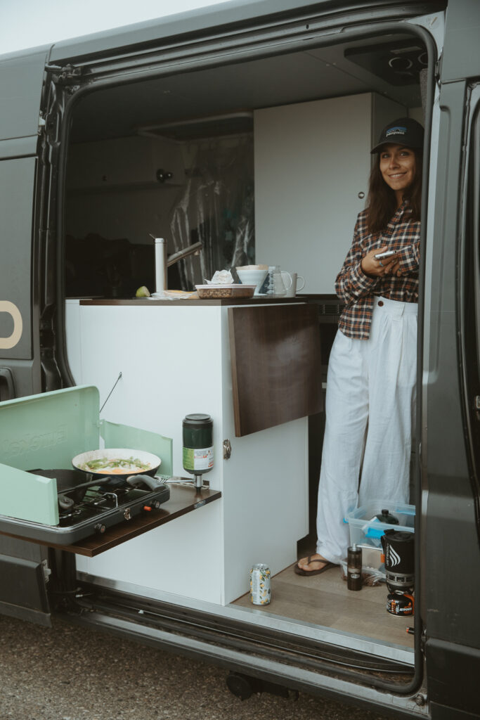 a woman standing in the doorway of a campervan