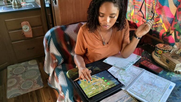 a woman with maps and an iPad planning a trip