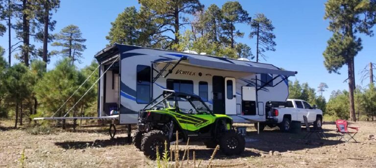 a toy hauler trailer with an ATV parked in front