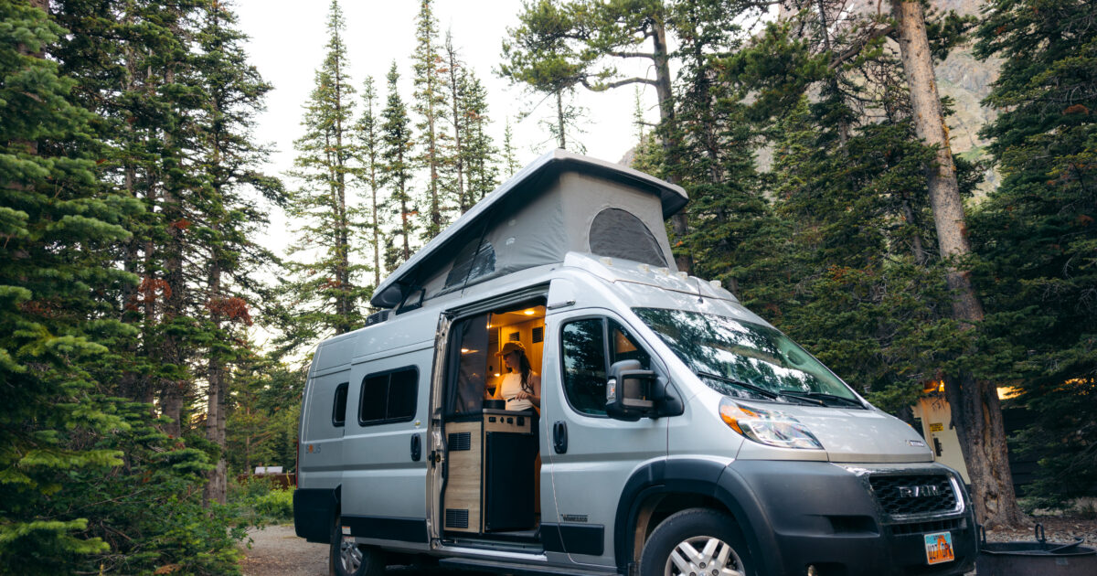A Class B camper parked in the woods