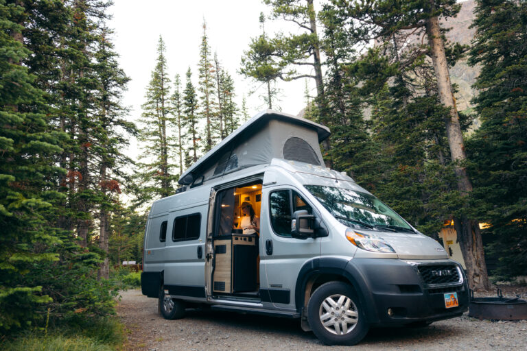 A Class B camper parked in the woods