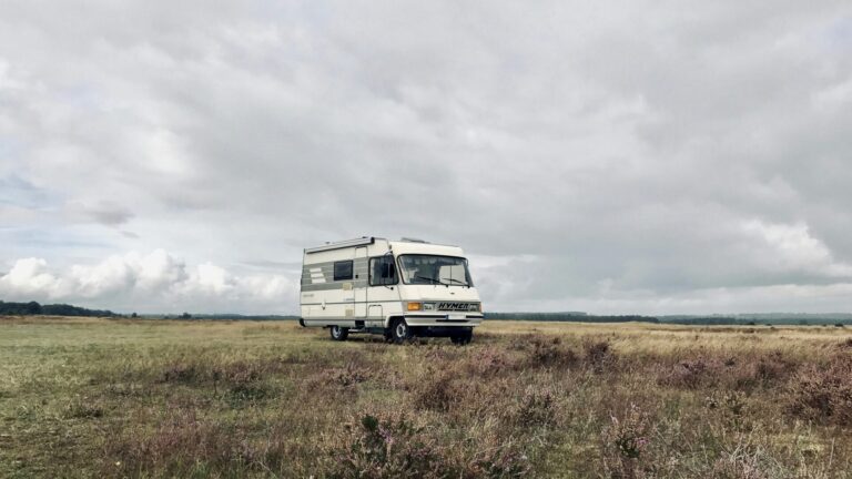 A used RV sitting in a field of grass