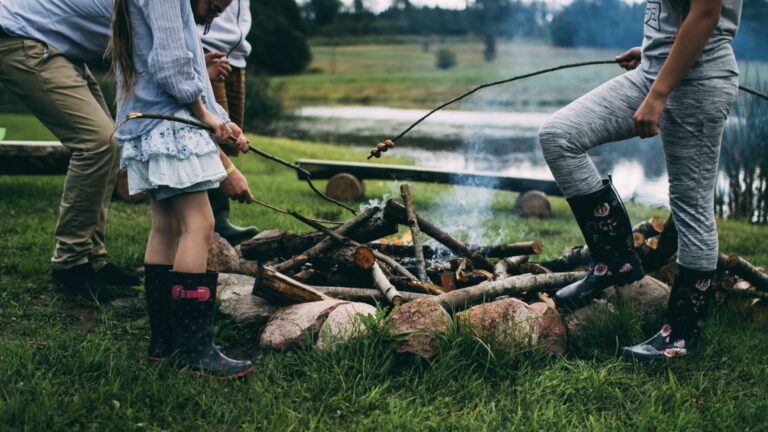 Family standing around a campfire, one of the best campground activities