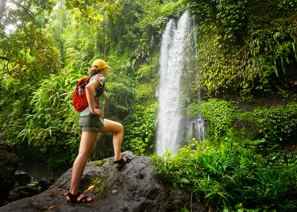 a woman hiking near a waterfall