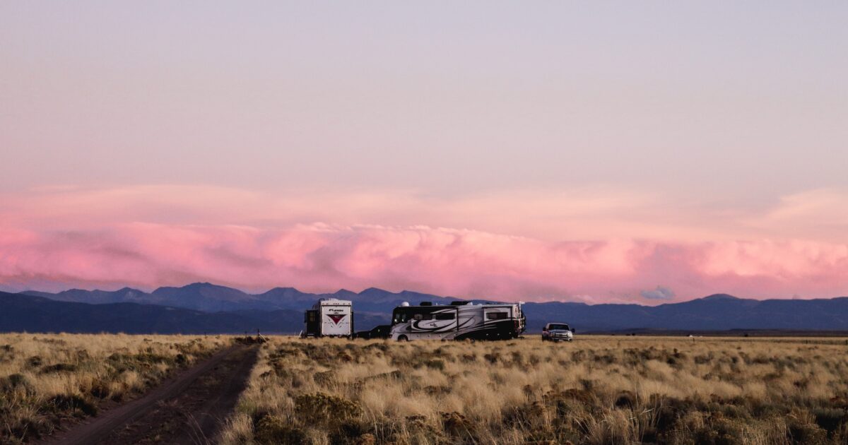 an RV parked on a plain with mountains beyond