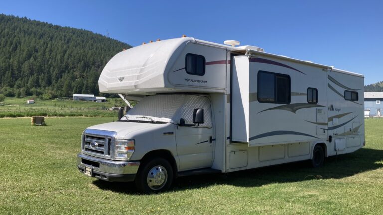 Class C RV sitting on green grass.