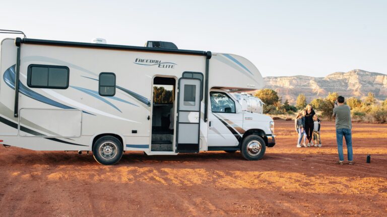Family that is buying an RV taking a picture in front of it