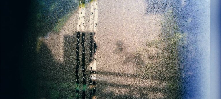 condensation dripping down a window screen in an RV