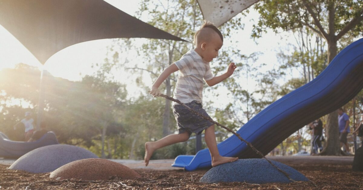 Little boy running on playground at kid-friendly campground