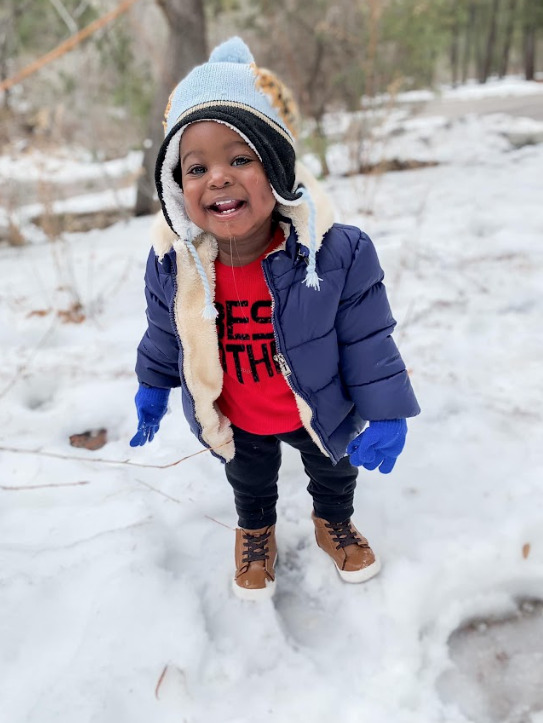 a little boy playing in the snow