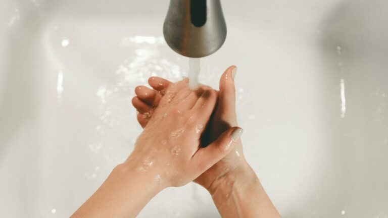 Person washing hands under RV faucet