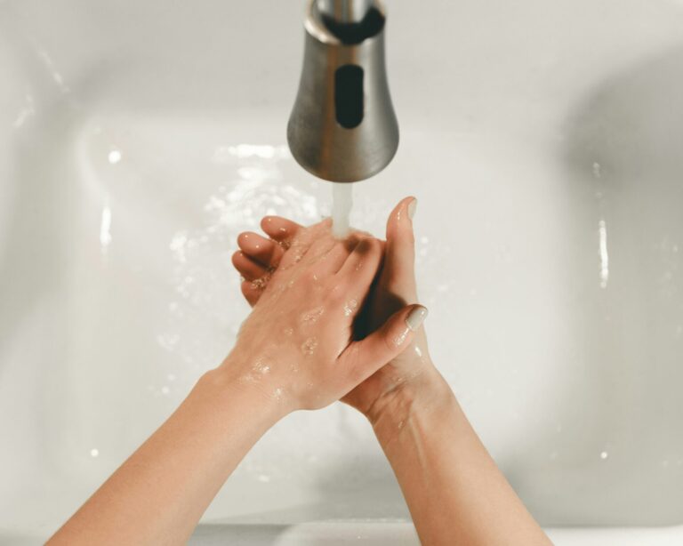 Person washing hands under RV faucet