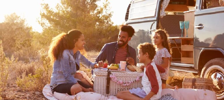 A family relaxes in front of their RV on vacation