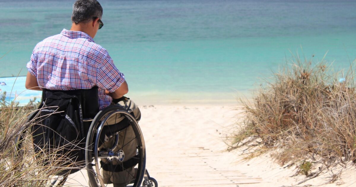 Person in wheelchair by the ocean, which he reached via handicap RV rental