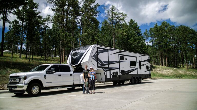 Family in front of fifth wheel after after buying an RV
