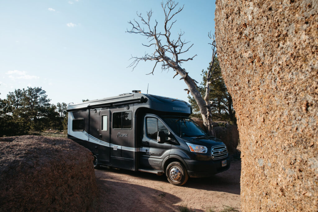 a Class C camper boondocking at a rocky campsite