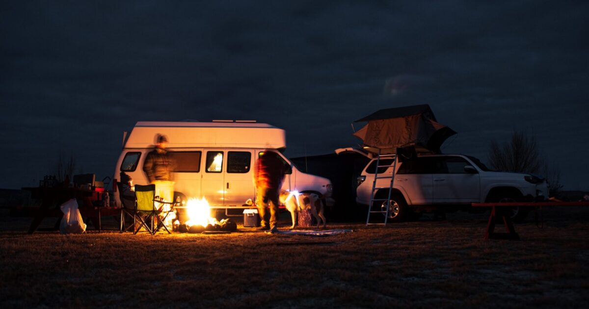 Campfire just outside a campervan