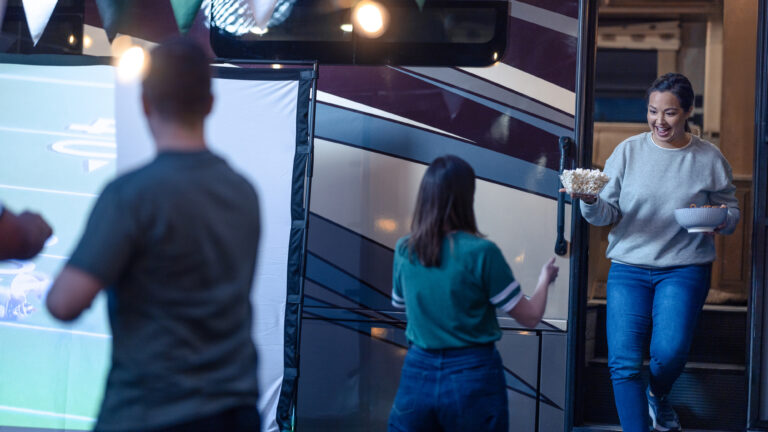 woman exiting an RV carrying a bowl of popcorn