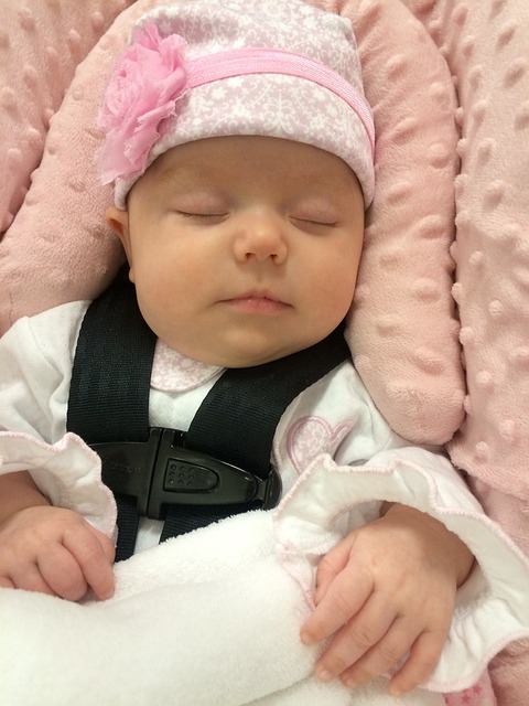 a baby asleep in her car seat