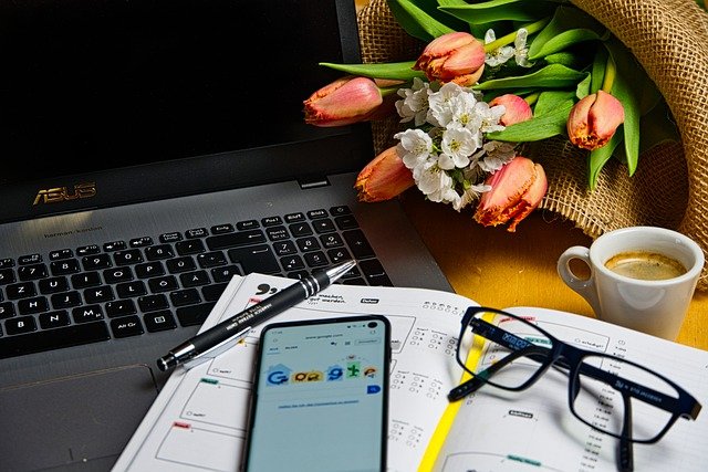 a closeup of a computer, cell phone, and other work from home items