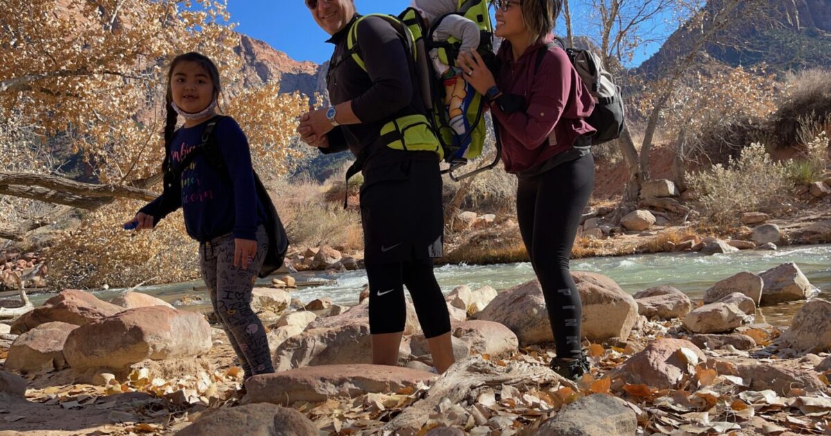 family hiking along a river