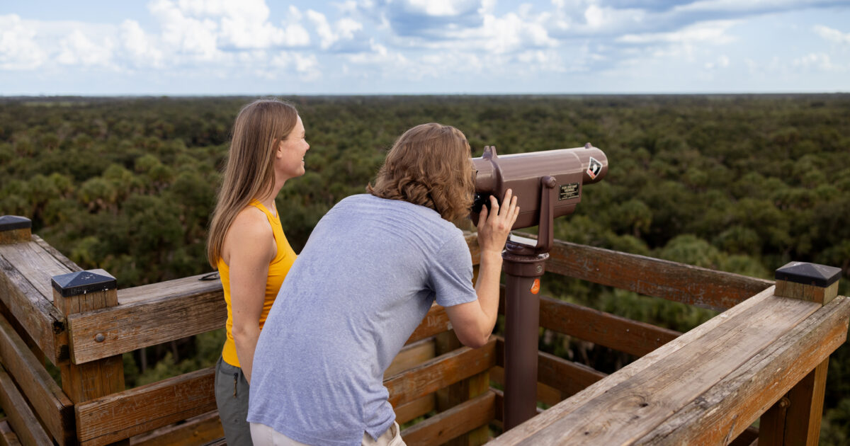 Two young people at a lookout point over a valley