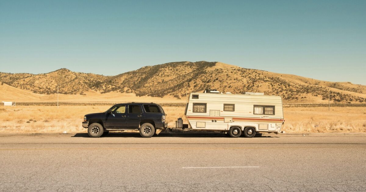 Truck and trailer in desert using tips for summer 2024 road trip